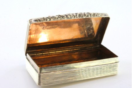 Caixa de rapé em prata gulhochada envolvendo cartela para monograma, motivos florais relevados na abertura e interior dourado do período de William IV.